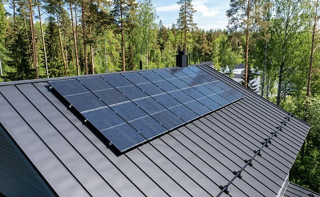 Aurinkopaneeleja asuinrakennuksen katolla.